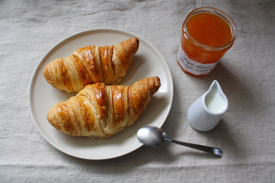 Croissants, Milch und Marmelade zum Frühstück